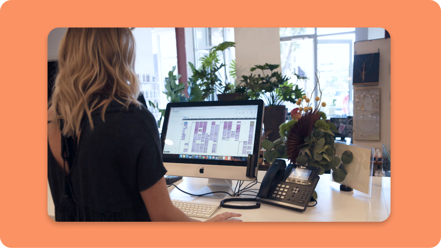 Person using Mindbody scheduling at front desk